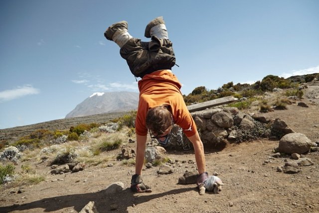 Alex D'Jamoos does a hand stand with Mt. Kilimanjaro in the back